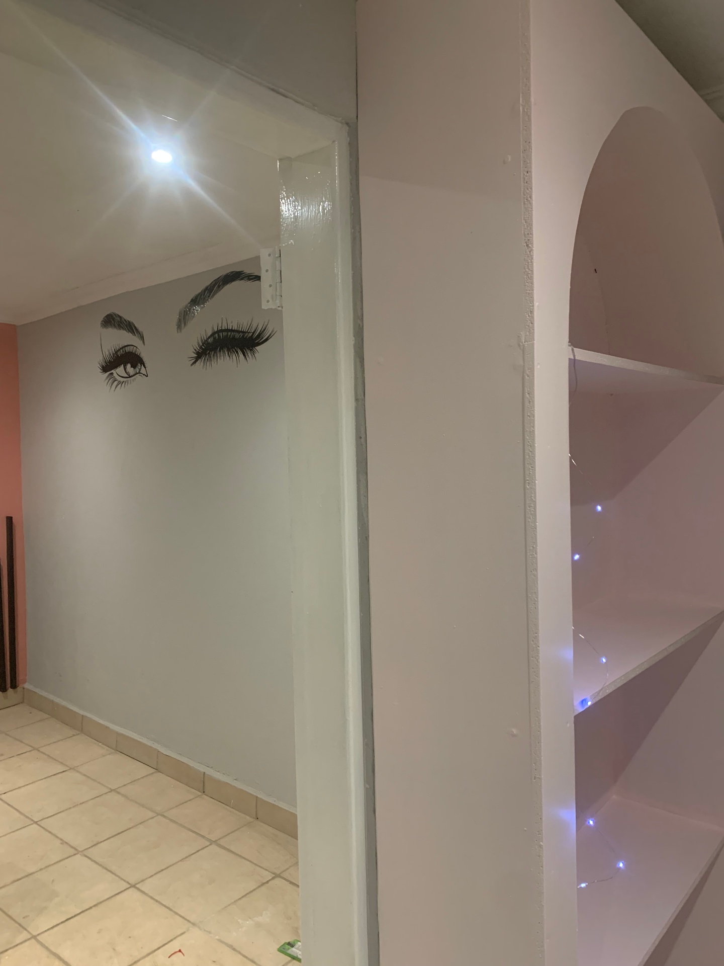Hair Vine salon corridor with lash mural and arched doorway