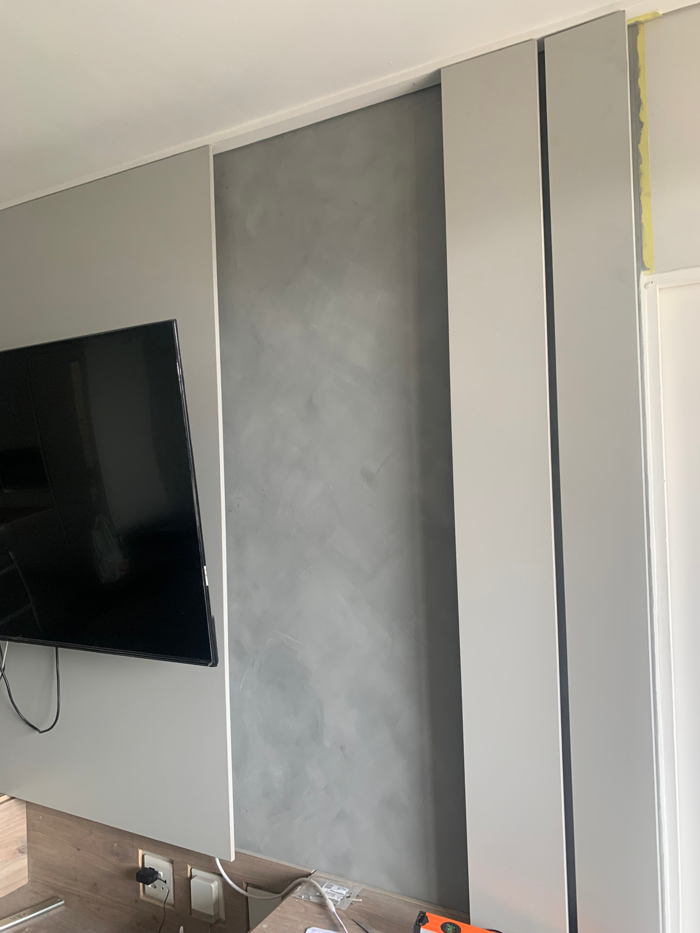 Daylight view of media wall in progress showing plaster feature and vertical fins